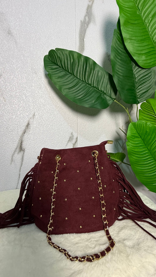 Bolso efecto ante burdeos con flecos y tachuelas doradas